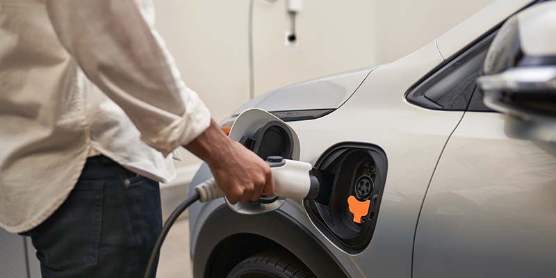 A man plugging in the charger of a 2025 Chevrolet Bolt EV