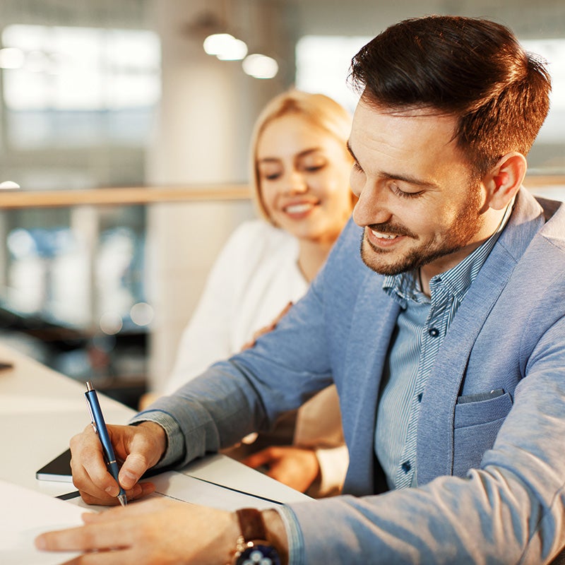 i.g. Burton Chevrolet of Berlin in Berlin MD couple siginging paperwork for their new car