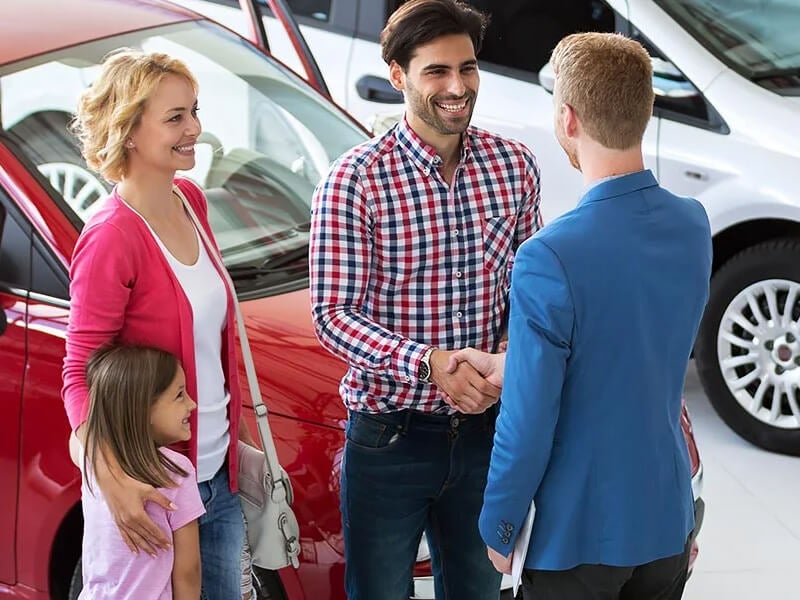 family shaking hands with service manager as they thinking about purchasing a new vehicle at i.g. Burton Chevrolet of Berlin